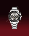 A stainless steel wristwatch with a silver-tone metal bracelet, a black bezel, and a gray dial featuring chronograph subdials and a moonphase indicator, shown against a dark red gradient background.