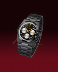 A black chronograph watch with a matching black metal link bracelet, featuring a black dial with silver subdials and gold accents, set against a dark red gradient background.