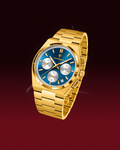 A gold-tone stainless steel watch with a blue dial and silver-tone subdials, shown on a dark red gradient background.