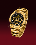 A luxury gold-tone watch with a black dial, gold chronograph subdials, and a gold metal link bracelet, shown against a dark red gradient background.